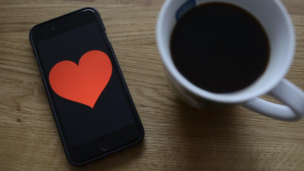 coffee and a phone with a hearth illustration on screen