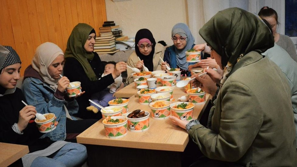 Women gather to have their meal after a day of fasting