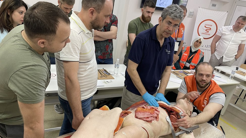 Dejvid Not ( u plavoj majici) pokazuje hirurške tehnike na medicinskoj lutki