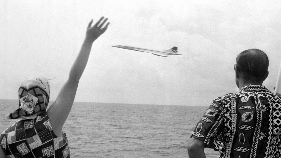 Queen Elizabeth II and the Duke of Edinburgh wave as Concorde flies by the Royal Yacht Britannia as the royal couple neared Barbados