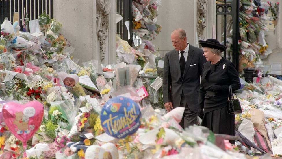 Britain's Queen Elizabeth II and the Duke of Edinburgh view the floral tributes to Diana, Princess of Wales, at Buckingham Palace, 1997