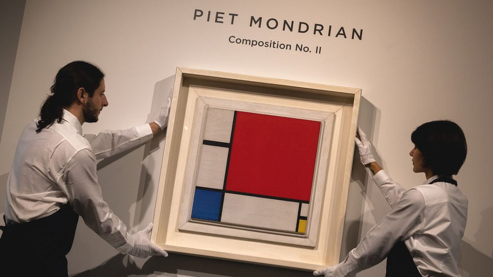 Painting on display and help by auctioneers at Sotheby's.