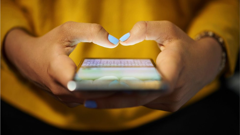 A woman typing on her smartphone