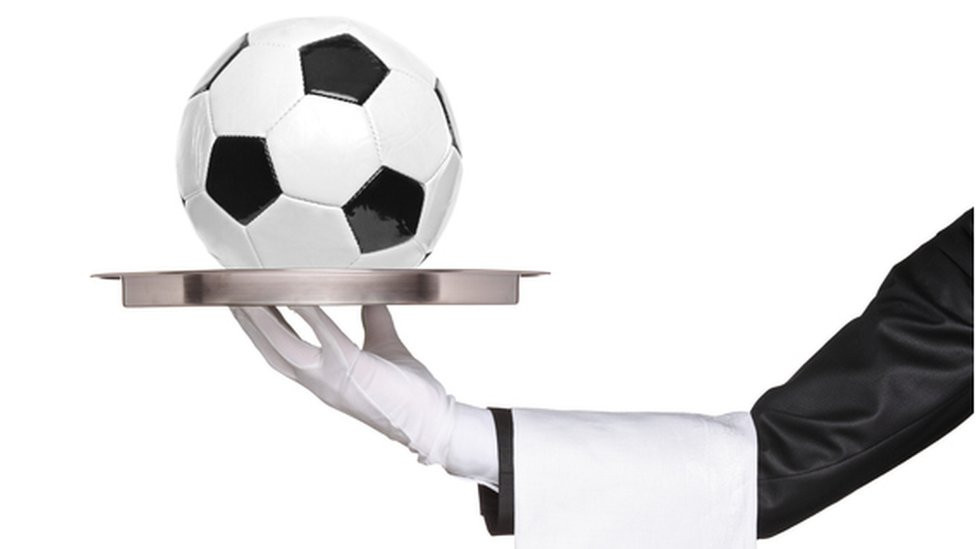 Garçom segurando uma bandeja com uma bola em cima
