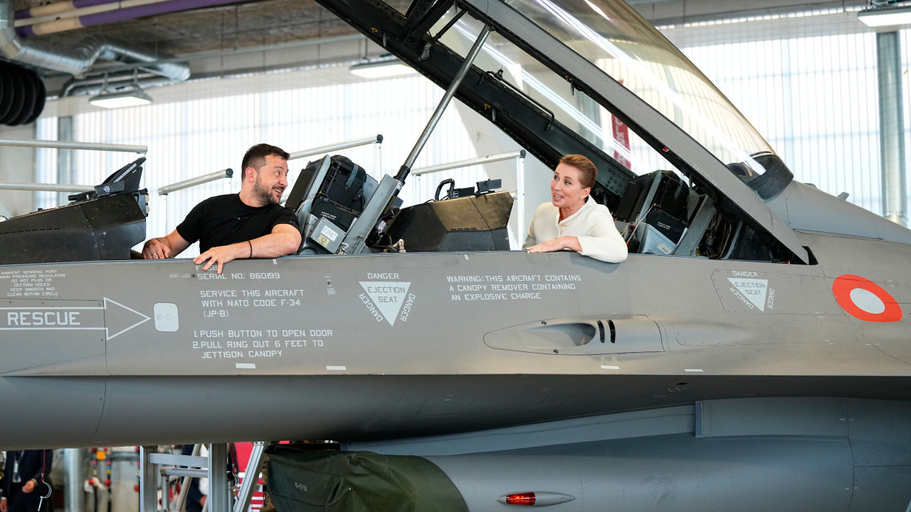 Ukrainian President Volodymyr Zelensky and Danish Prime Minister Mette Frederiksen sit in a F-16 fighter jet