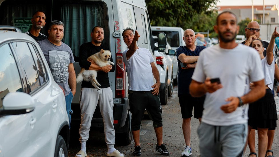 People gather at an area hit by rockets launched from the Gaza Strip, in Ashkelon, Israel