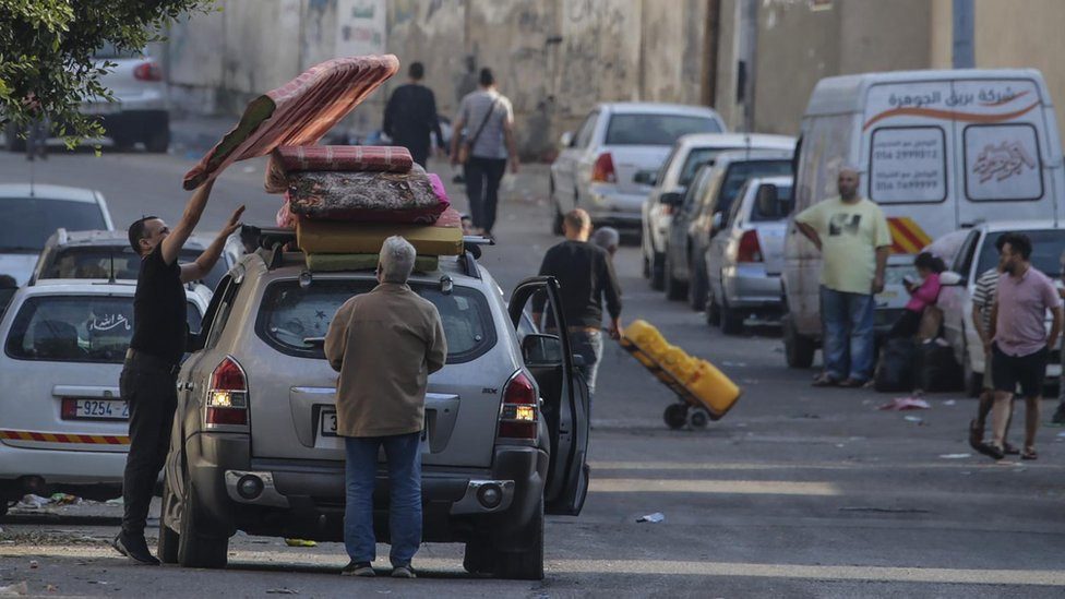 Residents of Gaza City load a car with their belongings as they begin to evacuate