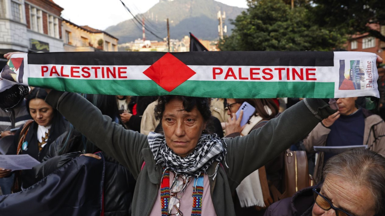 A woman holds a Palestine banner among protesters in Bogota, Colombia