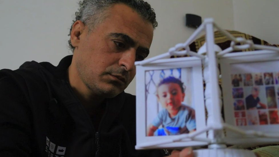 Abu Assi Arafat looks at pictures in his home