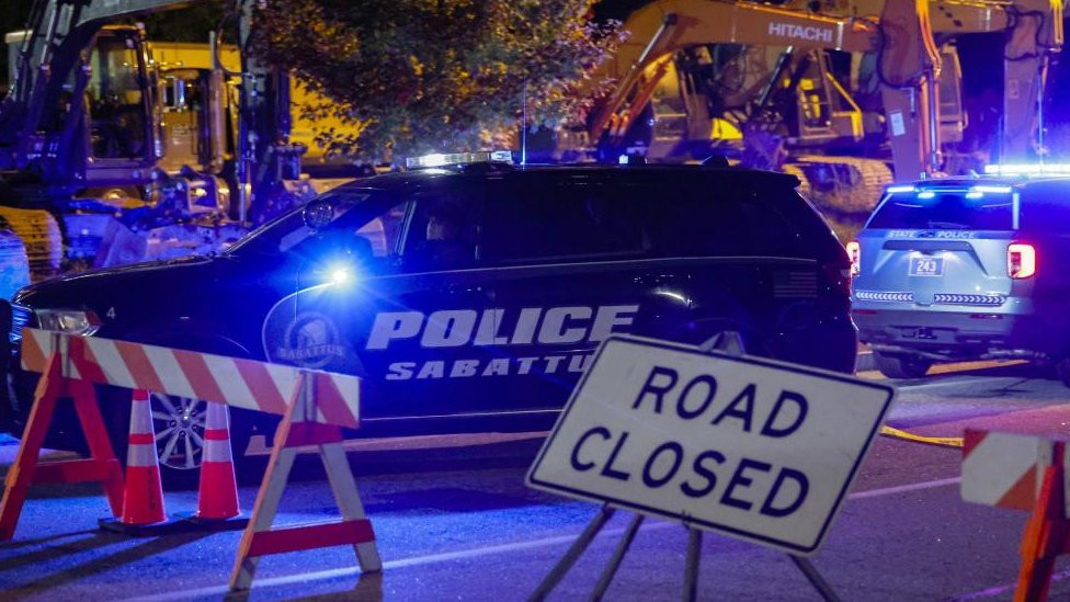 Police car next to road closed sign