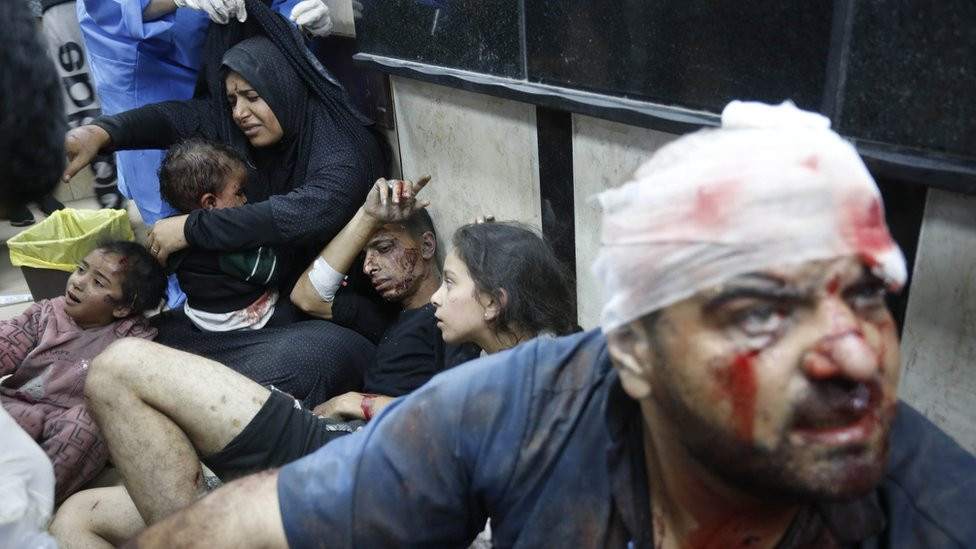 Casualties are treated while sitting on the floor at Al-Aqsa Martyrs Hospital in Deir al-Balah, in central Gaza (11 December 2023)