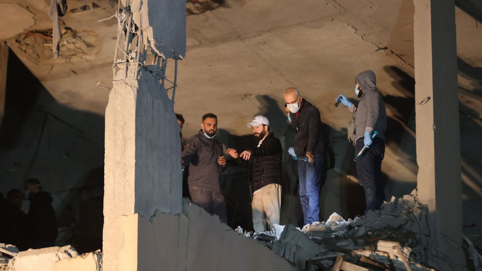 Lebanese emergency responders gather at the site of a strike, reported by Lebanese media to be an Israeli strike targeting a Hamas office, in the southern suburb of Beirut on January 2, 2024.