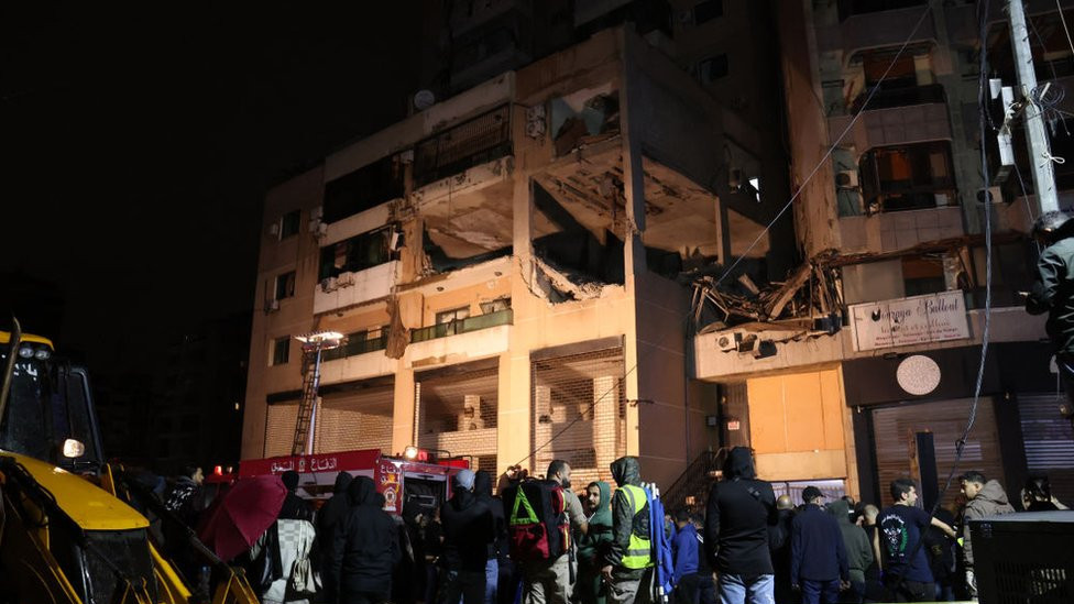 Lebanese emergency responders gather at the site of a strike, reported by Lebanese media to be an Israeli strike targeting a Hamas office, in the southern suburb of Beirut on January 2, 2024.