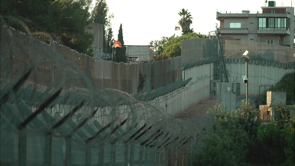 Ograda od bodljikave žice i kamere protežu se duž granice oko izraelskog grada Metule