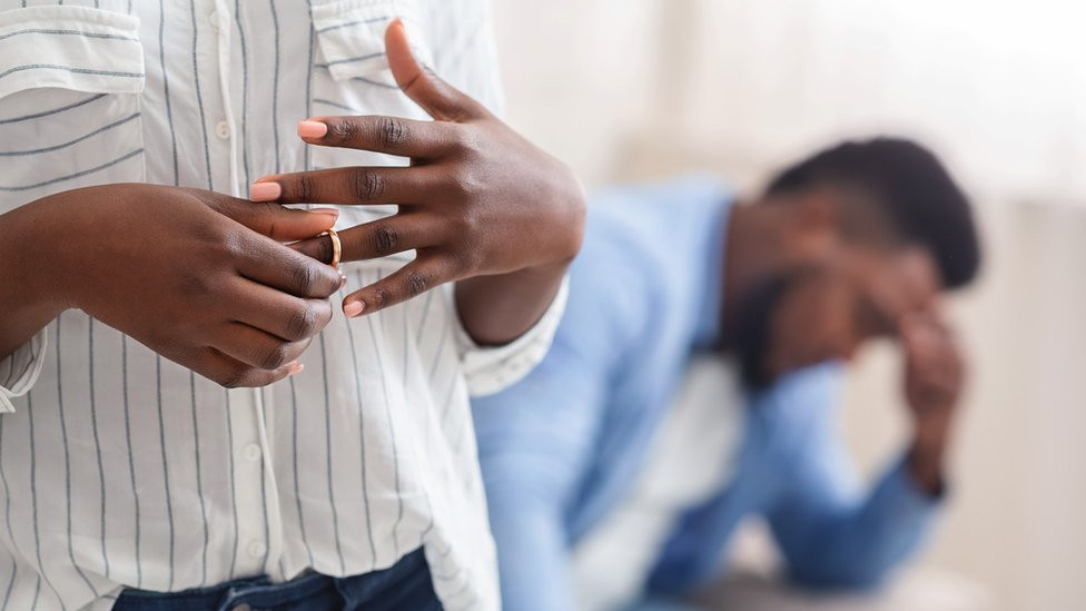 Unrecognizable black woman removing wedding ring from finger, divorcing with husband - stock photo