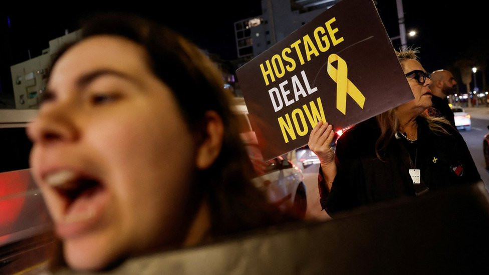 A woman holds up a sign saying "Hostage deal now" at a demonstration in Tel Aviv, Israel, demanding that the government negotiate the release of Israeli hostages held by Hamas in the Gaza Strip (5 March 2024)