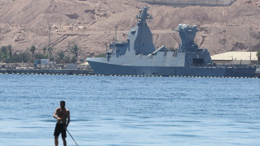 A man paddles in front of a German-made Sa'ar 6-class corvette of the Israeli navy docked at the Red Sea port city of Eilat on 16 April 2024