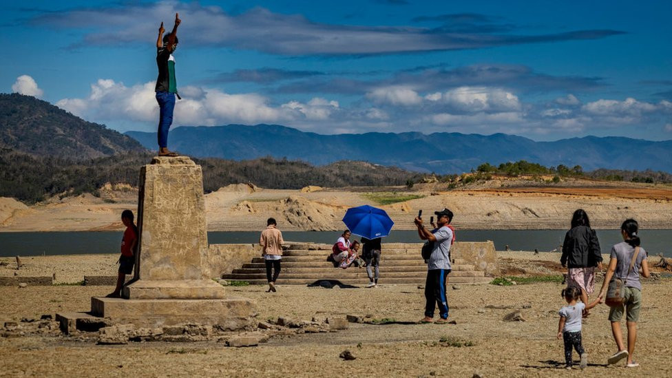 People visit the remnants of the old sunken town of Pantabangan on April 28, 2024 in Nueva Ecija province, Philippines. Due to a severe drought in the Philippines, a centuries-old settlement submerged since the 1970s has reemerged, attracting tourists despite the extreme heat.