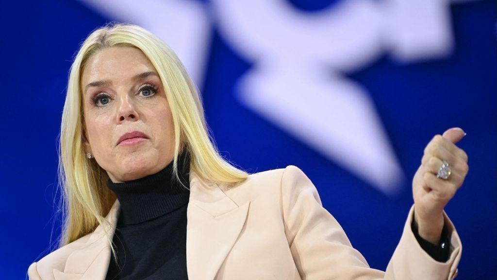 Pam Bondi govori na jednoj od konvencija konzervativaca u Merilendu u februaru. Ima ravnu plavu kosu, bež blejzer i crnu rolku ispod