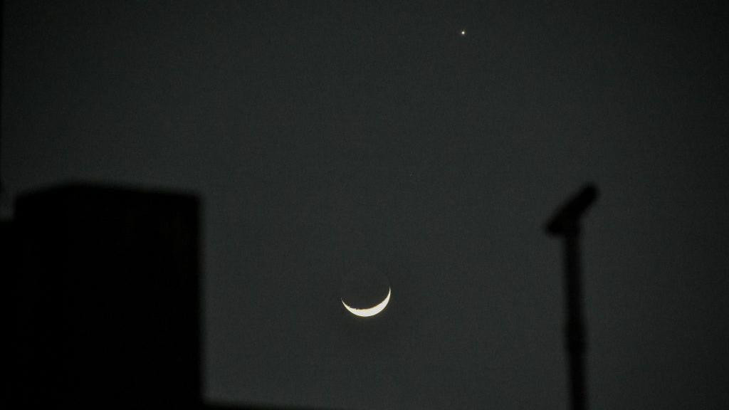 Venus appears beside a crescent moon in the night sky in Kolkata, India.