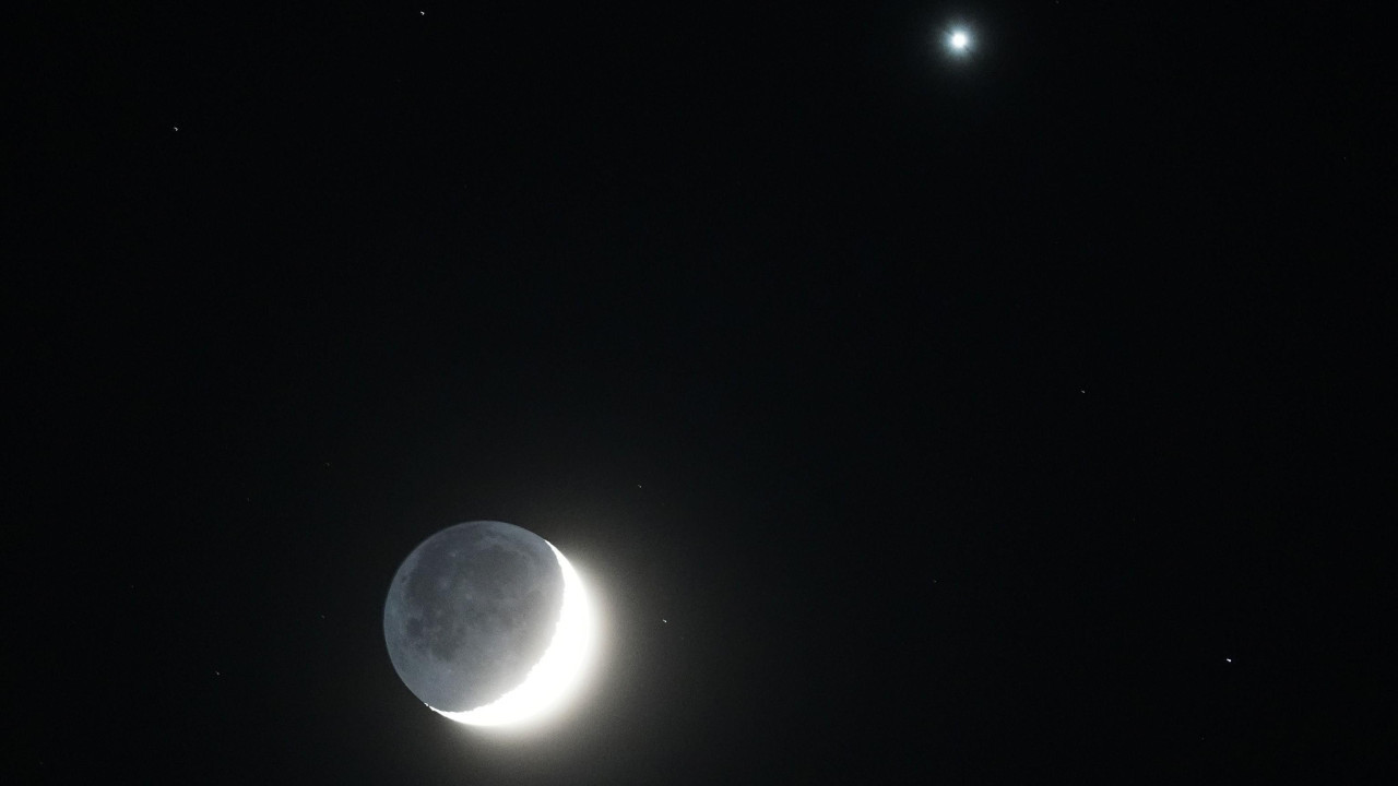 In the UK's Whitley Bay, a shining waxing crescent moon glows with Venus to the right