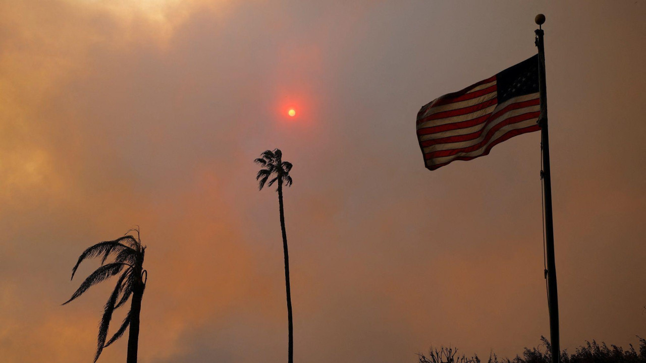 Crni gusti dim i dve spaljene palme pored američke zastave