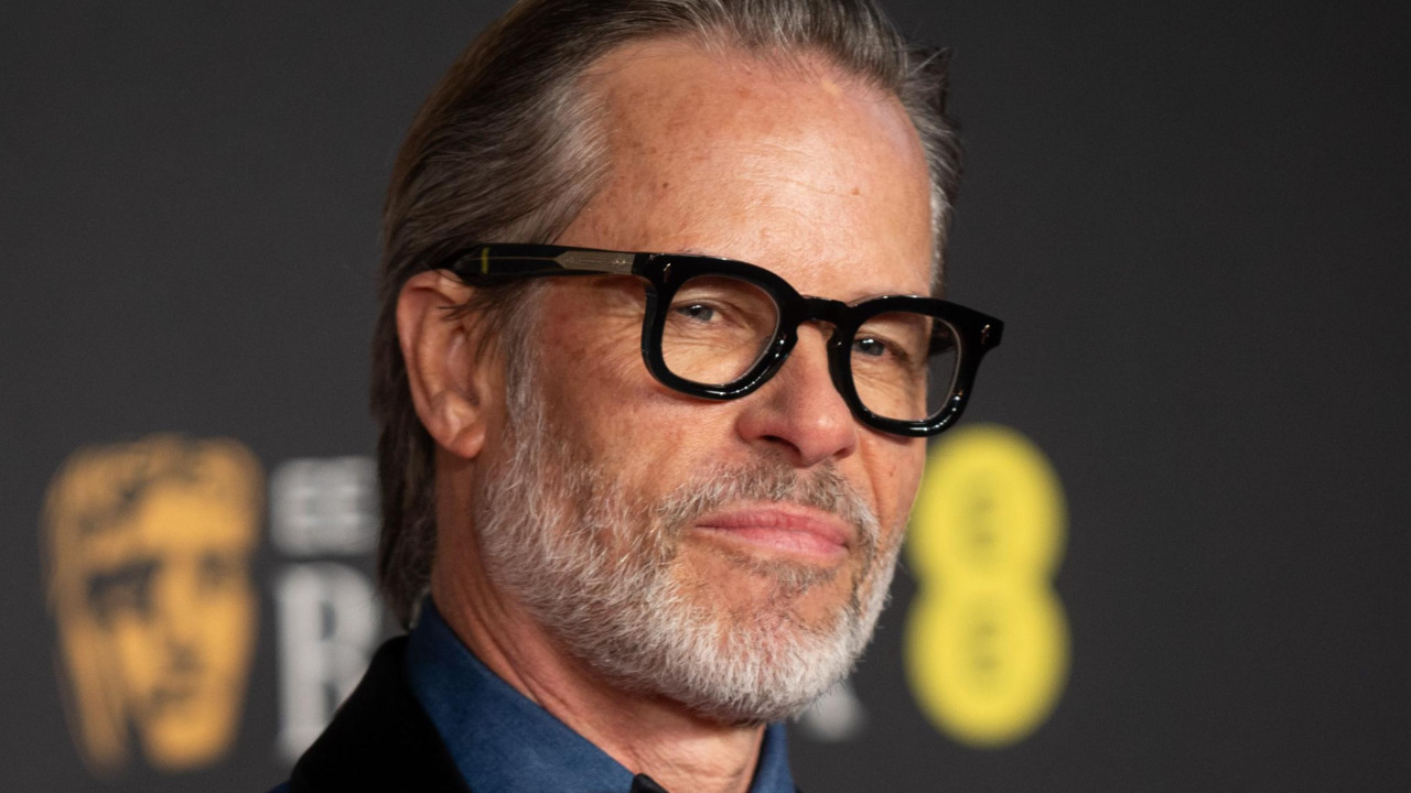 Guy Pearce wearing black round glasses