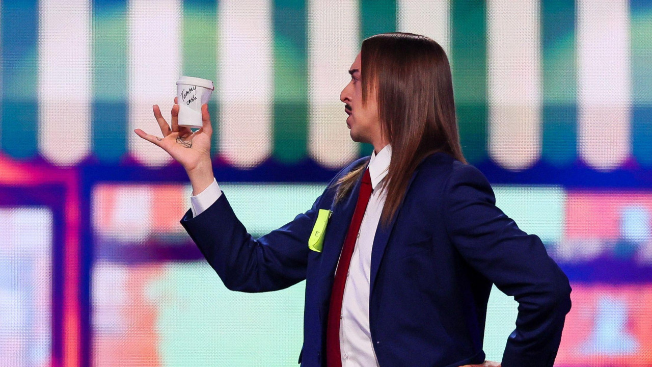 Muškarac sa dugom kosom drži šolju