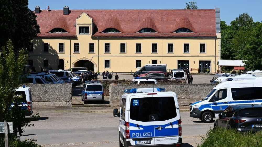Policijski automobili ispred velike žute zgrade