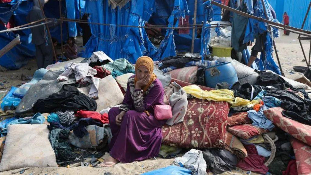Palestinka sedi na mestu izraelskog vazdušnog napada u šatoru u kojem su smešteni ljudi koji su bili primorani da napuste sopstvene domove.