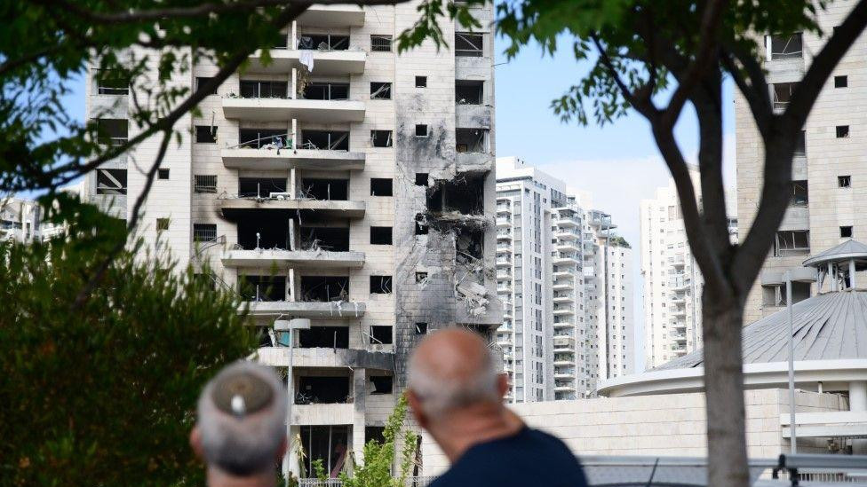Dva muškarca gledaju u pogođenu zgradu u Tel Avivu nakon iranskih napada