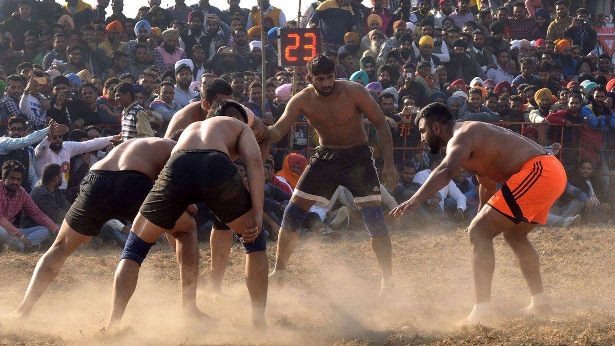 Kabadi, popularni sport u regionu, muškarci u šorcevima su poredani u krug, oko njih su navijači