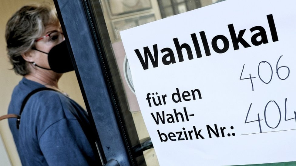 A woman enters a polling station to vote in the German general elections in Berlin, Germany, early 26 September 2021.