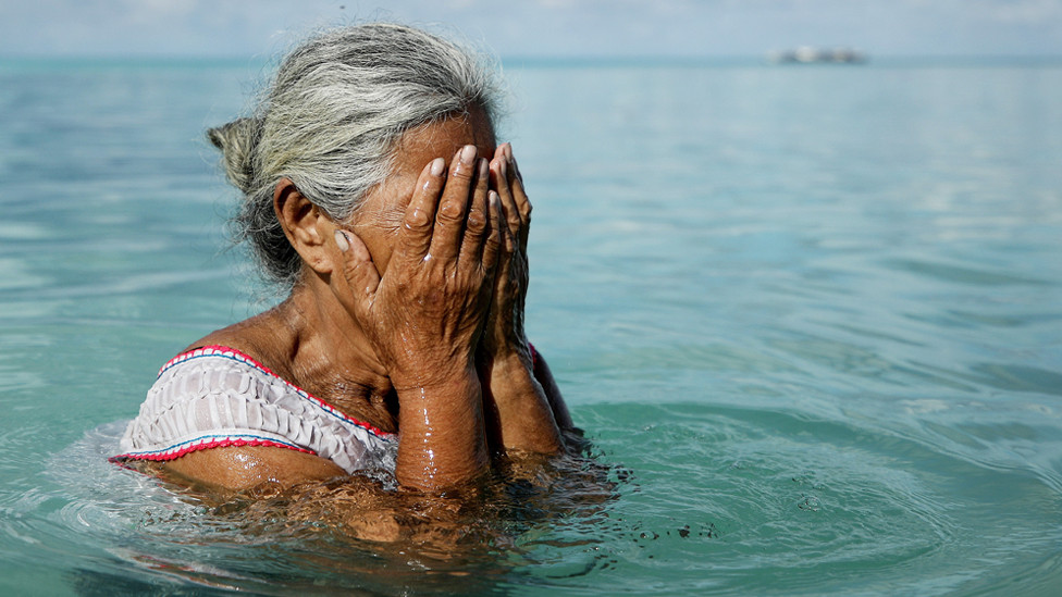 A woman stands in the lagoon on November 28, 2019 in Funafuti, Tuvalu, which has been classified as ‘extremely vulnerable’ to climate change by the United Nations Development Programme