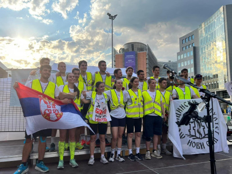 Muškarci i devojke na bini drže zastave